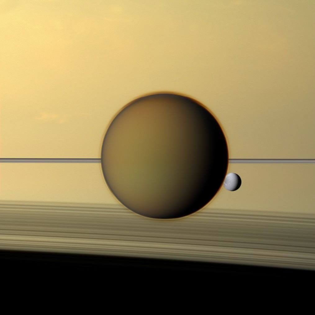 土星と環の一線を背に、タイタンの靄を透かして見える衛星ディオネ（自然色）